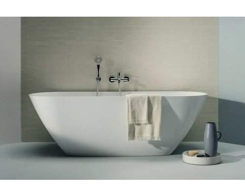 Badewanne LAUFEN LUA wandangebunden 85.5 x 170 cm weiß glänzend H2200870000001 Freistehende Badewanne mit Armatur, Handtuch und Badaccessoires in einem hellen Badezimmer.
