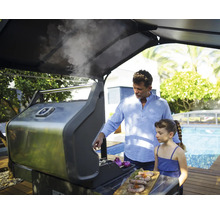 Vater und Tochter grillen Würstchen auf einem Gasgrill im Freien