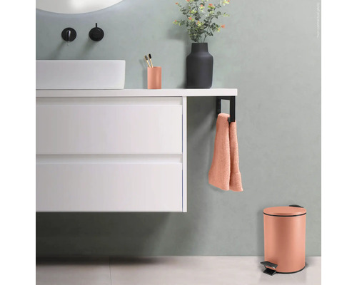 Modernes Badezimmer mit Waschbecken, Handtuch, Zahnputzbecher, Mülleimer und Vase