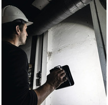 Handwerker mit LED-Arbeitsleuchte bei der Arbeit in Innenräumen