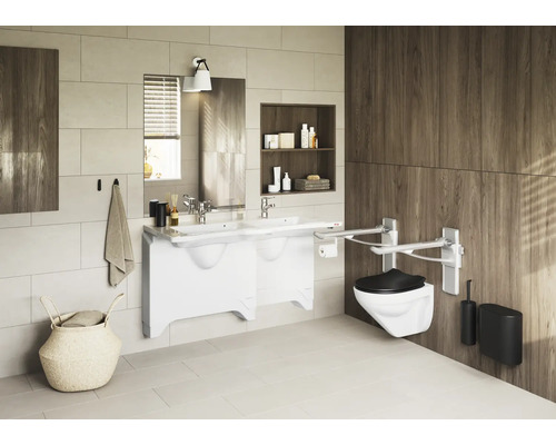 Badezimmer mit Waschtisch, Spiegel, Wandtoilette und Haltegriffen für Barrierefreiheit