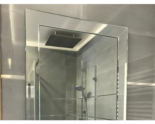 Duschkabine mit Duschkopf und Duscharmatur in einem Badezimmer mit grauen Fliesen