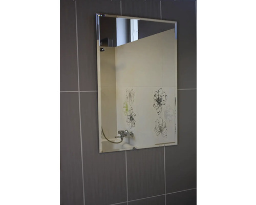 Rechteckiger Spiegel an einer Wand mit Fliesen