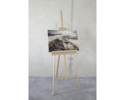 Staffelei mit Leinwandbild einer Berglandschaft im Nebel