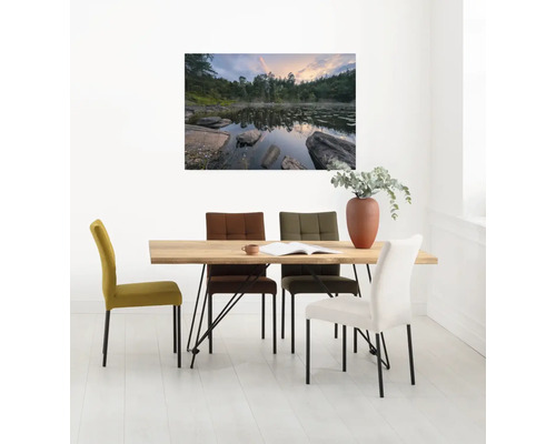 Esszimmer mit Holztisch und farbigen Polsterstühlen unter einem Landschaftsgemälde.