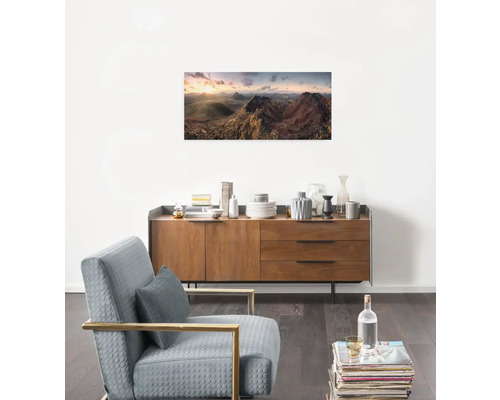 Wohnzimmer mit Kommode, Sessel und Landschaftsbild