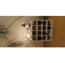 Weinregal mit Weinflaschen und Dekorationsartikeln an der Wand