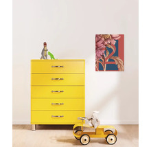 Gelbe Kommode mit fünf Schubladen und einem Bild mit floralem Muster an der Wand in einem Kinderzimmer.
