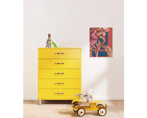 Gelbe Kommode mit fünf Schubladen und einem Bild mit floralem Muster an der Wand in einem Kinderzimmer.