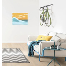Wohnzimmer mit Sofa, Beistelltisch, Teppich, Bild und Fahrradhalterung mit Fahrrad