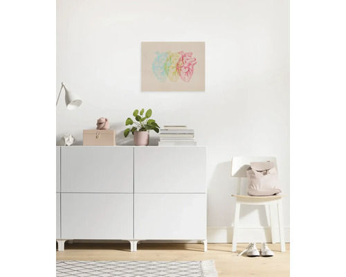 Dekoratives Wandbild mit drei Herzen im Pop-Art-Stil über einer weißen Kommode