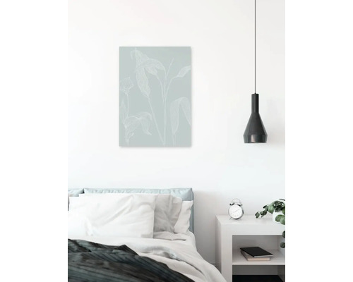 Schlafzimmer mit Bett, Nachttisch, Lampe und Wandbild mit Pflanzenmotiv