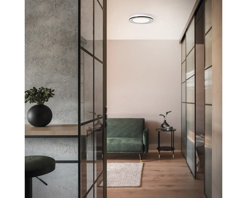 Wohnzimmer mit Deckenleuchte, Sofa, Glastüren und dekorativen Elementen für ein stilvolles Interieur