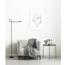 Wohnzimmer mit Sessel, Stehlampe und Wandbild