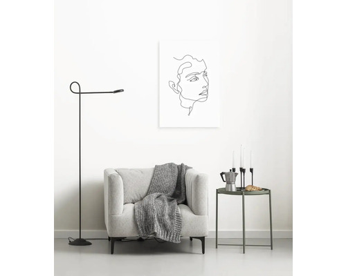 Wohnzimmer mit Sessel, Stehlampe und Wandbild