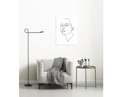 Wohnzimmer mit Sessel, Stehlampe, Beistelltisch und Wandbild