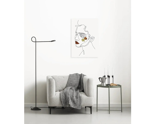 Wohnzimmer mit Sessel, Stehlampe, Beistelltisch und Wandbild