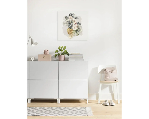 Wohnraum mit Kommode, Stuhl und einem Wandbild mit Ananas-Motiv