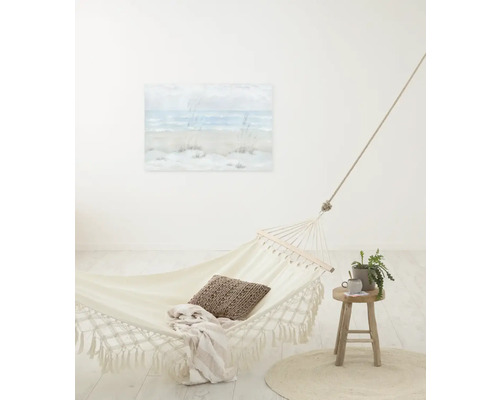 Helle Szene mit Tuchhängematte, Kissen, Decke und Beistelltisch mit Pflanze