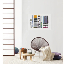 Wohnzimmer mit Stuhl, Beistelltischen, Kissen, Teppich und Wandbild
