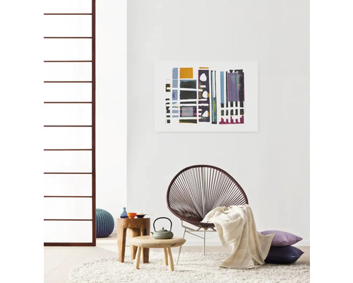 Wohnzimmer mit Stuhl, Beistelltischen, Kissen, Teppich und Wandbild
