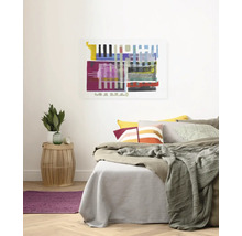 Helles Schlafzimmer mit Bett, Kissen, Überwurf, Beistelltisch und abstrakter Kunst an der Wand