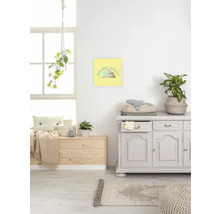 Szene eines hellen Raumes mit Kommode, Holzkiste, Teppich und gerahmtem Bild mit der Aufschrift Precious Bounty an der Wand