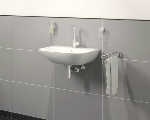 Hänge-Waschbecken mit Armatur, Seifenspender, Zahnputzbecher und Handtuchhalter vor grauer Wand
