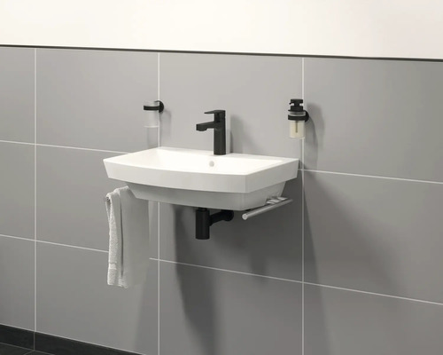 Modernes Badezimmerwaschbecken mit Armatur, Handtuch und Seifenspender an grauer Fliesenwand