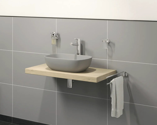 Badezimmerwaschtisch mit Aufsatzwaschbecken, Armatur, Seifenspender, Zahnputzbecher und Handtuchhalter vor gefliesener Wand