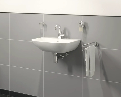 Modernes Badezimmer mit Waschbecken, Armatur, Seifenspender und Handtuchhalter an der Wand.