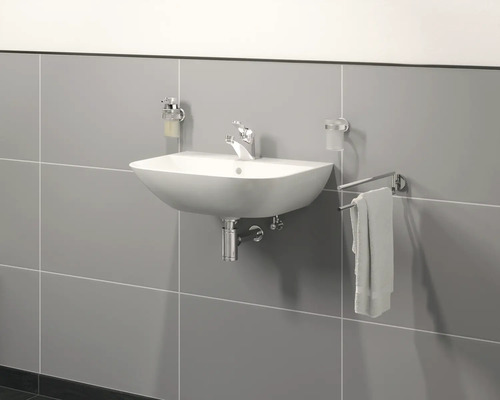 Waschtisch mit Armatur, Seifenspender und Handtuchhalter an einer gefliesten Wand