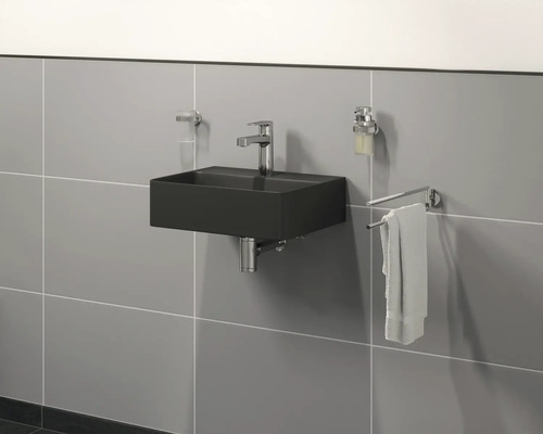 Modernes Badezimmer mit schwarzem Waschbecken, Armatur, Seifenspender und Handtuchhalter an der Wand.