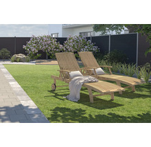 Gartenszene mit zwei Holzliegen auf Rasenfläche und Sichtschutzzaun im Hintergrund