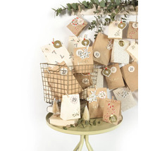 Dekorativer Adventskalender mit Papierbeuteln in einem Drahtkorb auf einem Tisch.