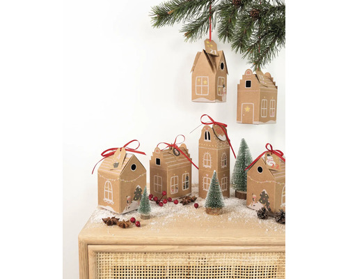 Dekorative Adventskalender-Häuschen aus Karton mit rotem Band auf einem Tisch