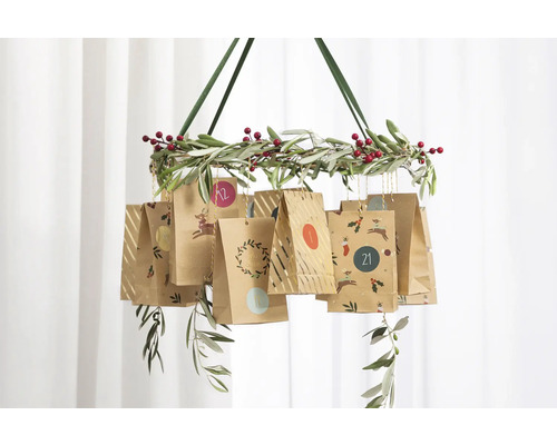 Hängender Adventskalender mit Papierbeuteln an einem Kranz