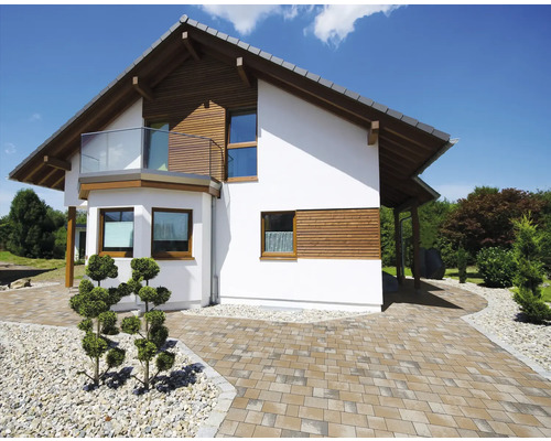 Außenansicht eines modernen Hauses mit Pflasterweg und Garten