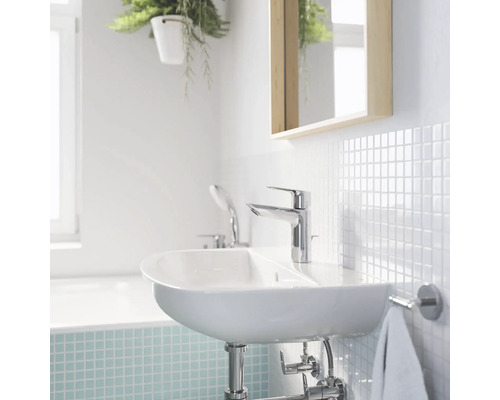 Helles Badezimmer mit Waschbecken, Armatur, Spiegel und Fliesen