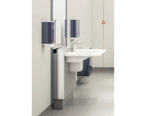 Waschtisch mit Armatur, Seifenspender und Papierhandtuchspender an einer Wand