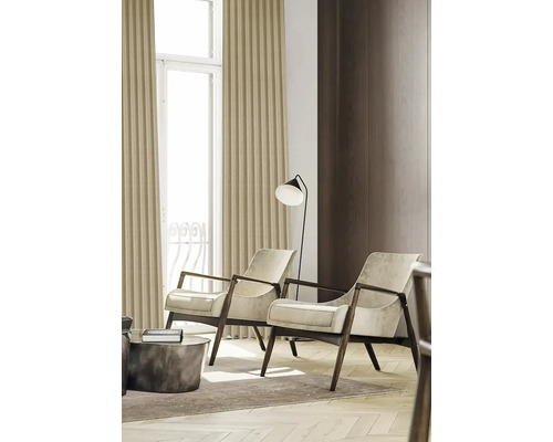 Wohnzimmer mit zwei Sesseln und Stehlampe neben einem Fenster mit Vorhängen.