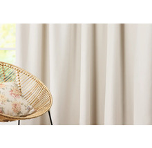 Gardine und Korbsessel mit Kissen vor einem Fenster