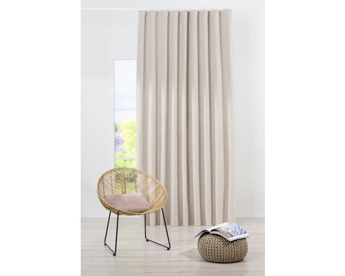 Dekorativer Vorhang neben Sessel und Hocker in einem hellen Raum.