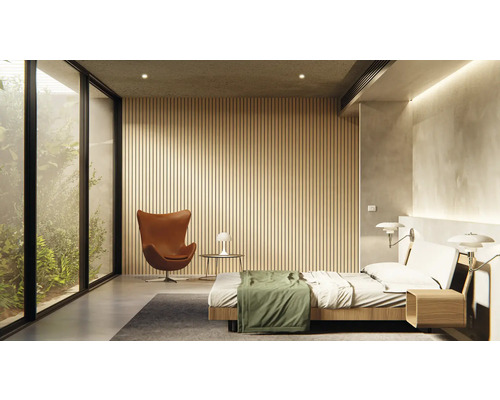 Helles Schlafzimmer mit Doppelbett, Sessel und großem Fenster mit Blick ins Grüne