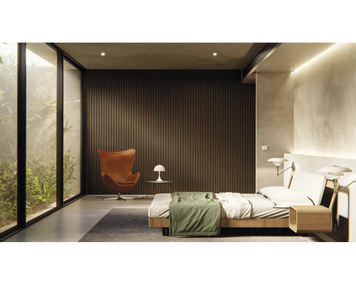 Helles Schlafzimmer mit Bett, Sessel und großem Fenster mit Blick ins Grüne