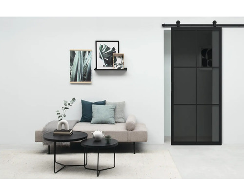Wohnzimmer mit Sofa, Couchtischen, Wanddekorationen und Schiebetür