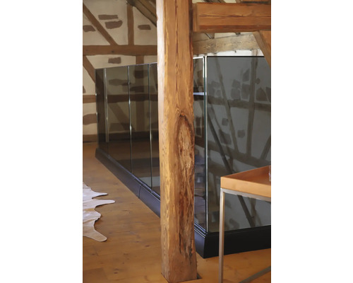 Innenaufnahme eines Raumes mit Holzfußboden, Holzbalken und Glasgeländer.