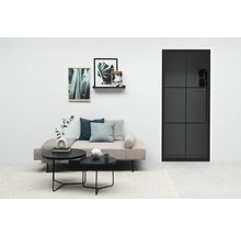 Wohnzimmer mit Sofa, Couchtischen, Bildern und einer schwarzen Tür