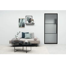 Helles Wohnzimmer mit Tagesbett, Couchtischen, Dekoration und Tür mit Glaseinsatz