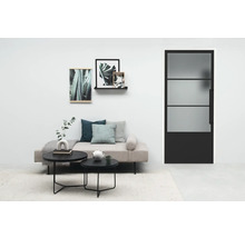 Wohnzimmer mit Sofa, Couchtischen und einer Tür mit Glaseinsatz